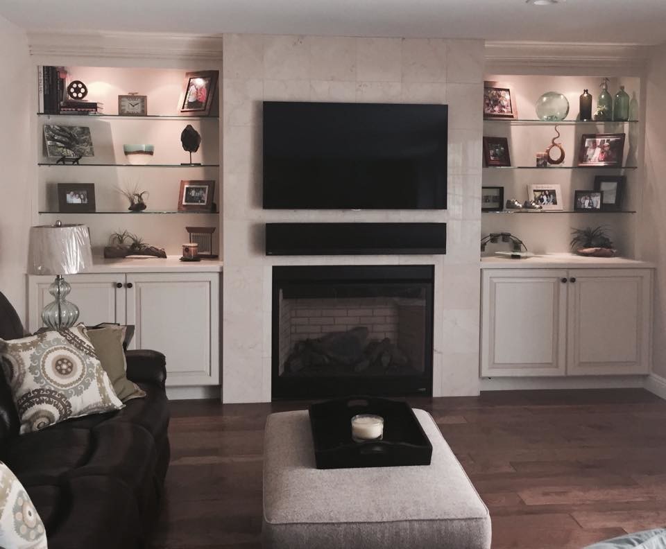 Mittelgroßes, Offenes Klassisches Wohnzimmer mit beiger Wandfarbe, dunklem Holzboden, Kamin, Kaminumrandung aus Stein und TV-Wand in Orange County