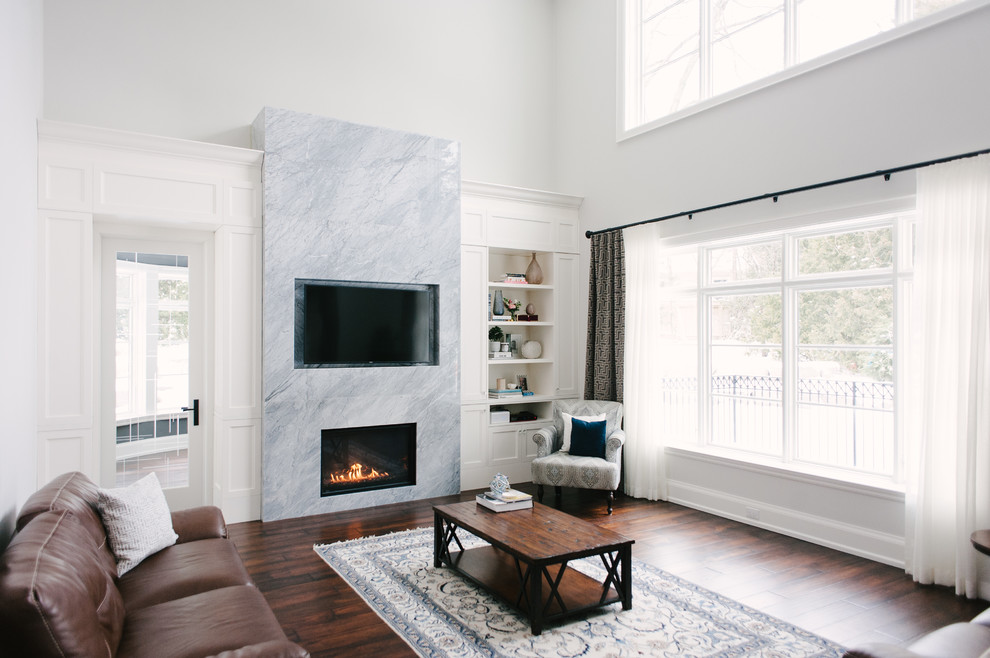 Example of a mid-sized trendy open concept dark wood floor and brown floor family room design in Toronto with white walls, a standard fireplace, a stone fireplace and a media wall
