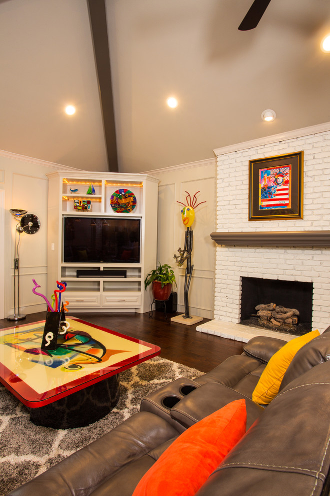 ダラスにある中くらいなエクレクティックスタイルのおしゃれな独立型ファミリールーム (ベージュの壁、無垢フローリング、標準型暖炉、レンガの暖炉まわり、壁掛け型テレビ、茶色い床) の写真