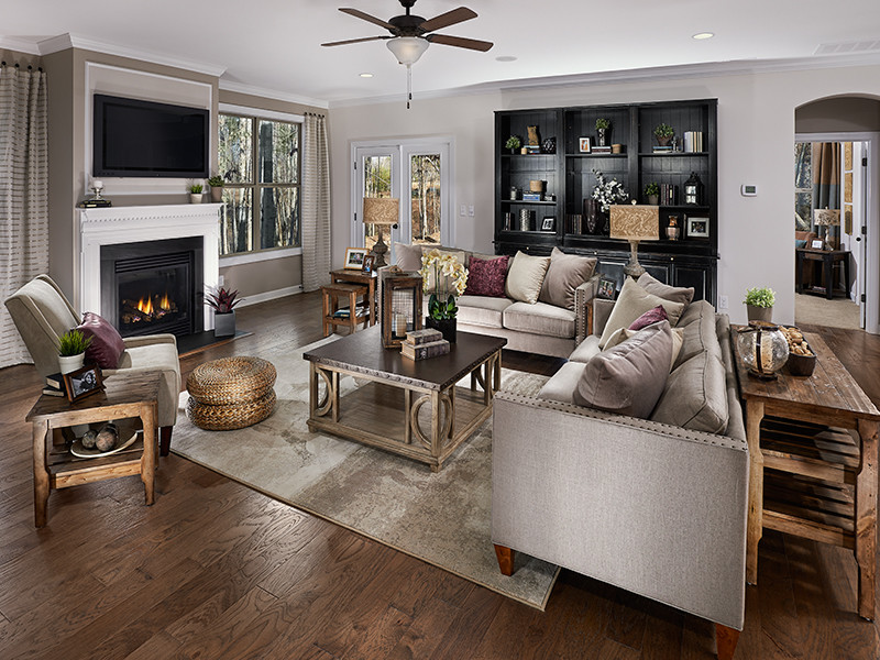 Medium sized rustic open plan games room in Orlando with grey walls, medium hardwood flooring, a standard fireplace, a plastered fireplace surround and a wall mounted tv.