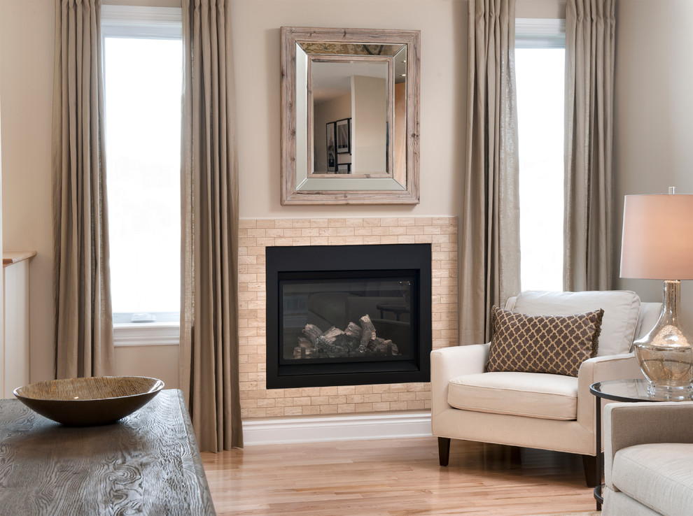This is an example of a medium sized classic open plan games room in Ottawa with beige walls, light hardwood flooring, a standard fireplace and a tiled fireplace surround.