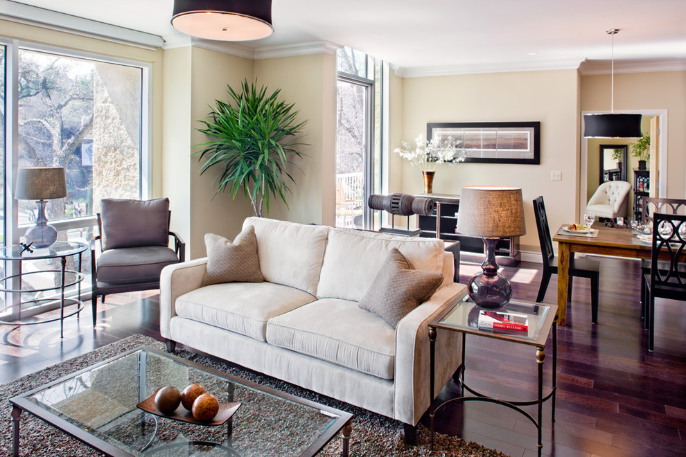 Diseño de sala de estar abierta minimalista grande sin chimenea con paredes beige, suelo de madera oscura, televisor colgado en la pared y suelo marrón