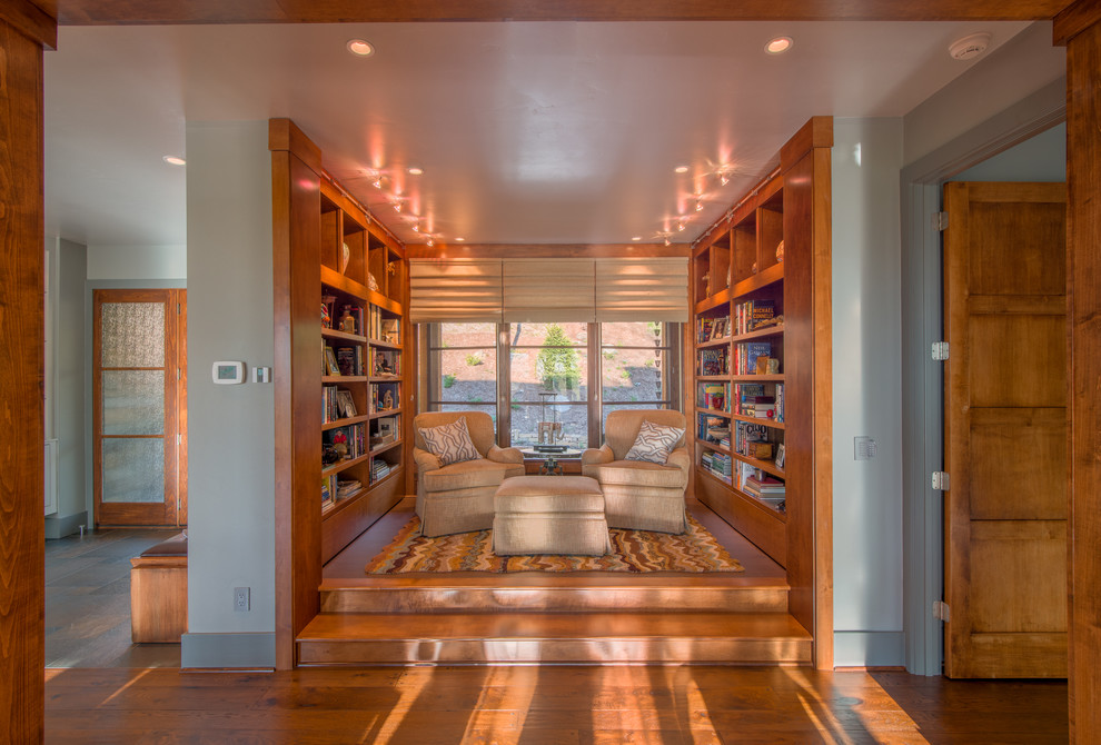 Immagine di un piccolo soggiorno chic aperto con libreria, pavimento in legno massello medio, nessun camino e nessuna TV