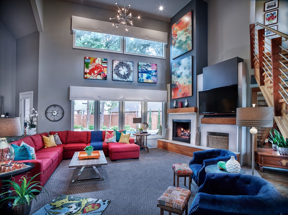 Imagen de sala de estar abierta actual con paredes grises, moqueta, todas las chimeneas, marco de chimenea de metal, televisor colgado en la pared, suelo gris y alfombra