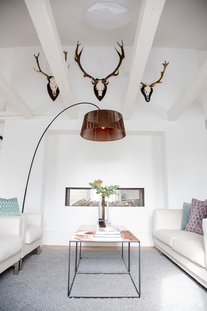 Mittelgroßes, Fernseherloses, Abgetrenntes Stilmix Wohnzimmer mit weißer Wandfarbe, hellem Holzboden, Tunnelkamin, verputzter Kaminumrandung und braunem Boden in Kopenhagen