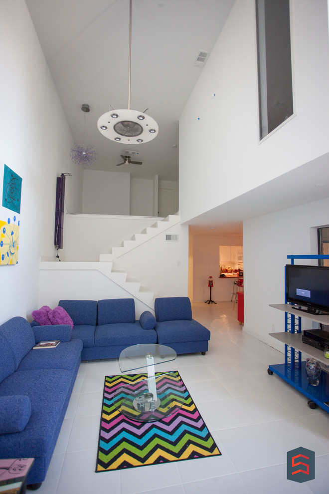 Modelo de sala de estar abierta ecléctica de tamaño medio sin chimenea con paredes blancas, suelo de baldosas de cerámica y televisor independiente