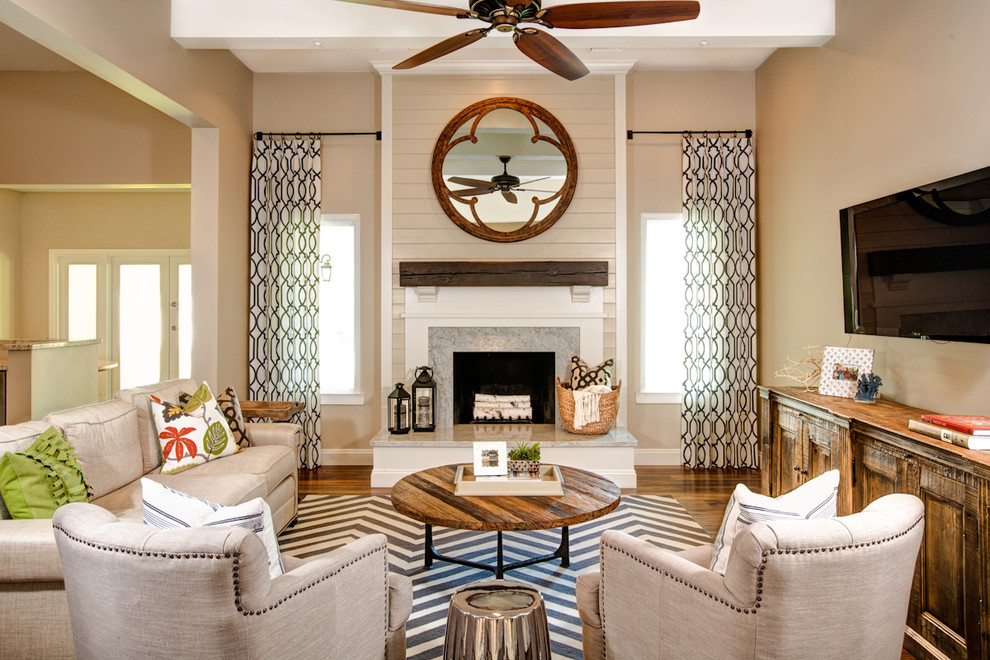 Imagen de sala de estar abierta rústica con paredes beige, suelo de madera en tonos medios, todas las chimeneas y televisor colgado en la pared