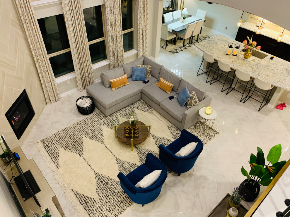 На фото: большая открытая гостиная комната в стиле модернизм с бежевыми стенами, мраморным полом, угловым камином, фасадом камина из плитки, отдельно стоящим телевизором и белым полом