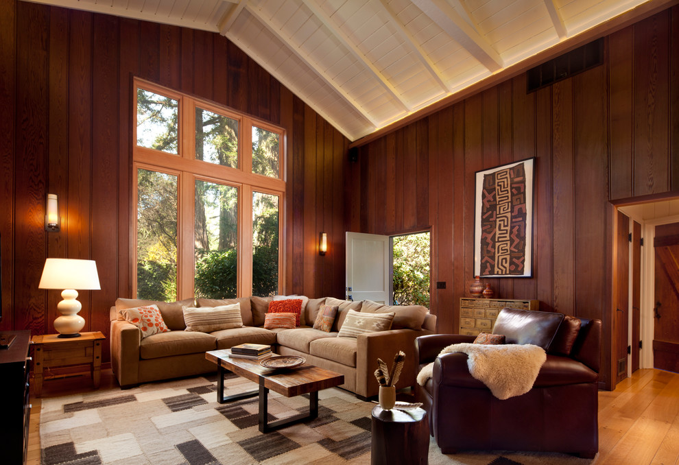 Exemple d'une grande salle de séjour tendance ouverte avec un mur marron, un sol en bois brun et aucune cheminée.