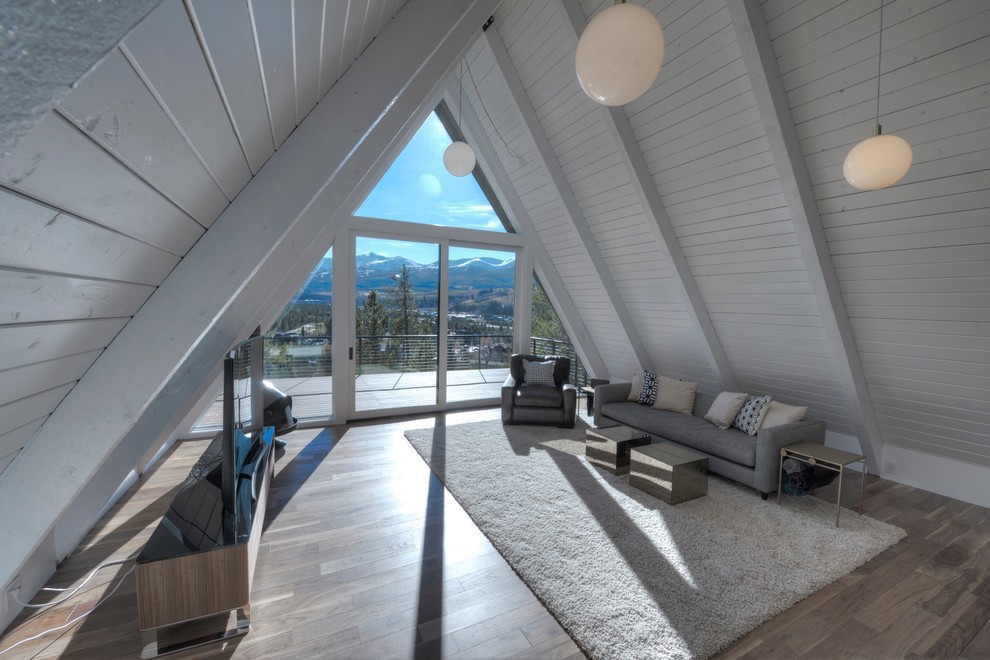 Mittelgroßes Modernes Wohnzimmer im Loft-Stil mit weißer Wandfarbe, braunem Holzboden, Hängekamin, Kaminumrandung aus Metall, freistehendem TV und braunem Boden in Denver