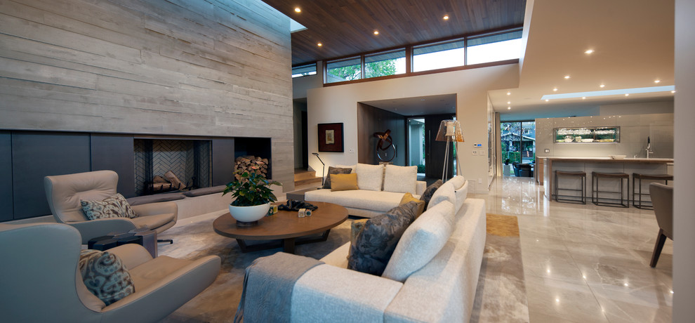 Großes, Fernseherloses, Offenes Modernes Wohnzimmer mit beiger Wandfarbe, Marmorboden, Kamin und Kaminumrandung aus Beton in Calgary
