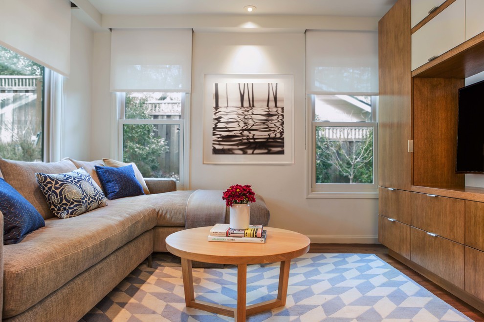 Свежая идея для дизайна: открытая гостиная комната среднего размера в современном стиле с белыми стенами, паркетным полом среднего тона, телевизором на стене и коричневым полом без камина - отличное фото интерьера