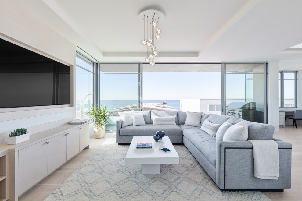 Diseño de sala de estar abierta contemporánea con suelo de madera clara, televisor colgado en la pared, suelo beige y bandeja