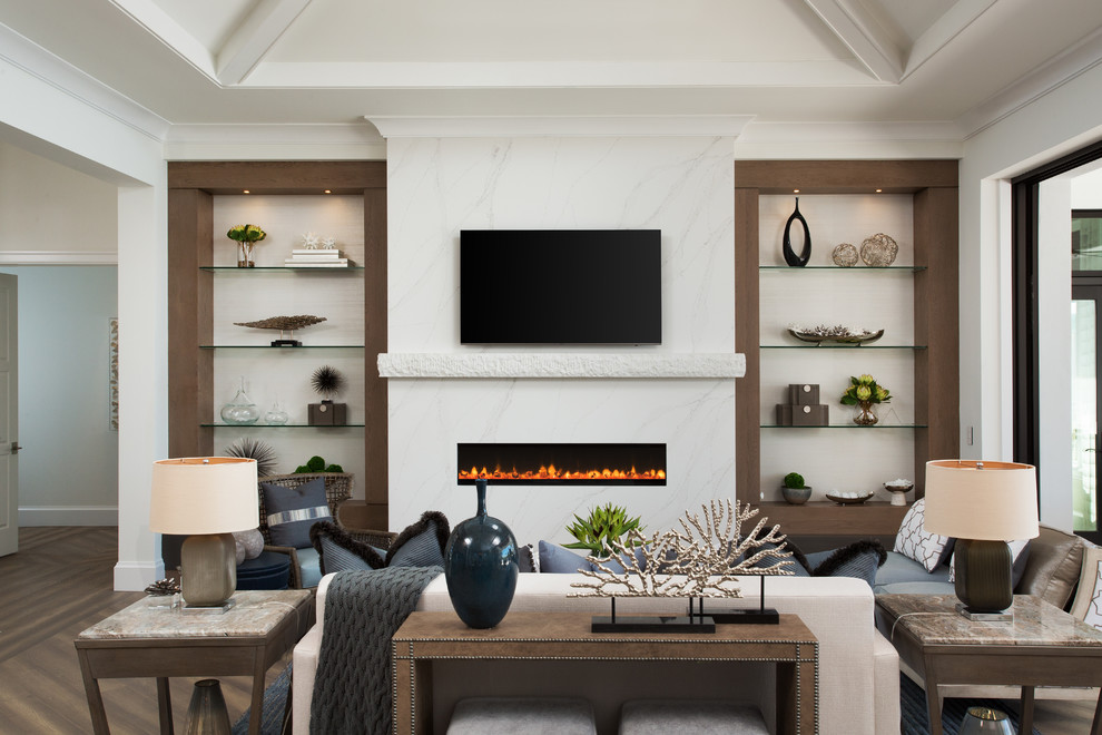 Klassisk inredning av ett mellanstort allrum, med mellanmörkt trägolv, vita väggar, en bred öppen spis och en väggmonterad TV