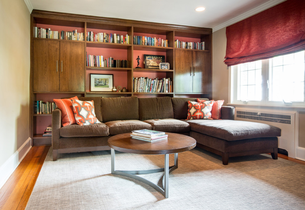 Imagen de sala de estar con biblioteca cerrada tradicional renovada de tamaño medio con paredes beige, suelo de madera en tonos medios y suelo beige
