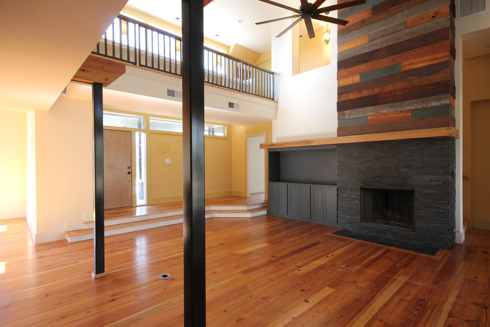 Mittelgroßes, Offenes Modernes Wohnzimmer mit beiger Wandfarbe, braunem Holzboden und Kaminumrandung aus Stein in Atlanta