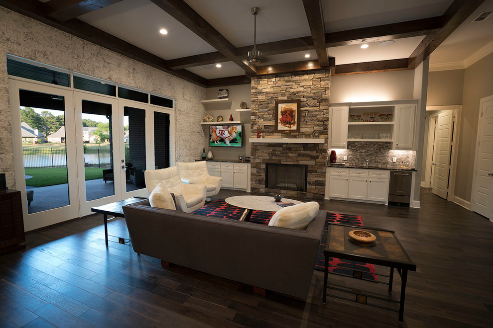Inspiration for a large rustic open plan games room in Other with a home bar, grey walls, dark hardwood flooring, a wall mounted tv and a stone fireplace surround.