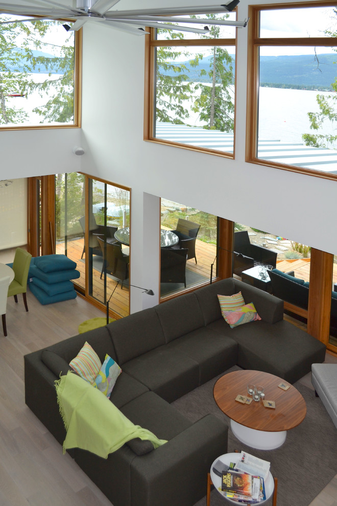 Mittelgroßes, Fernseherloses Modernes Wohnzimmer mit weißer Wandfarbe und hellem Holzboden in Calgary