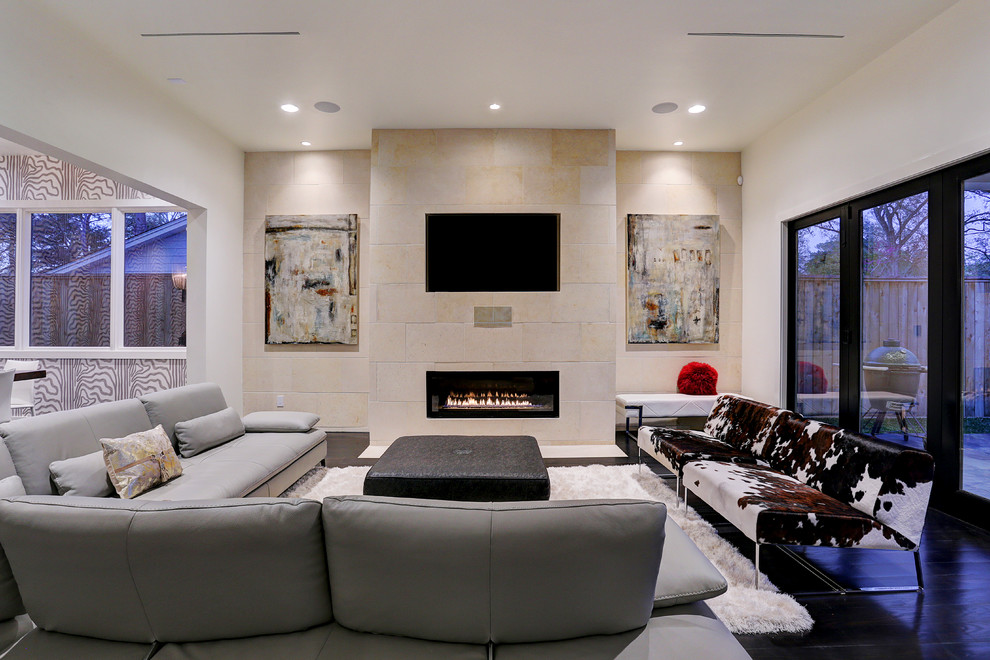 Свежая идея для дизайна: большая открытая гостиная комната в стиле модернизм с серыми стенами, полом из винила, стандартным камином, фасадом камина из плитки, мультимедийным центром и коричневым полом - отличное фото интерьера