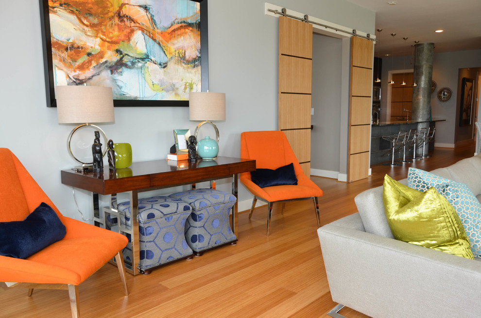 Immagine di un grande soggiorno design stile loft con pareti grigie, pavimento in bambù, TV a parete e pavimento arancione