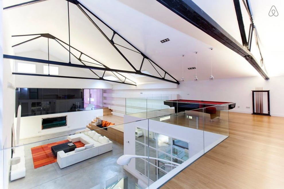 Foto di un ampio soggiorno minimalista stile loft con sala giochi, pareti bianche, pavimento in bambù e pavimento beige