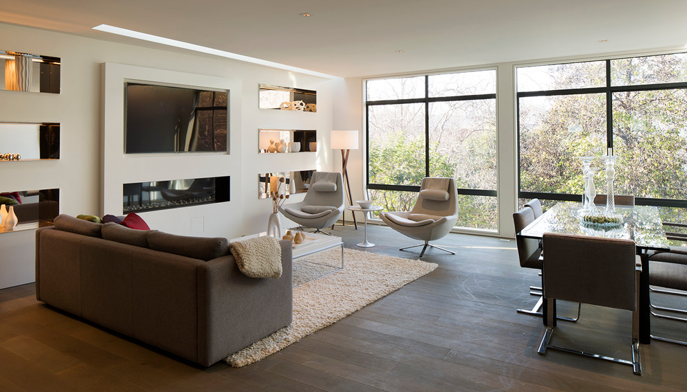 Imagen de sala de estar abierta moderna de tamaño medio con paredes blancas, suelo de madera oscura, chimenea lineal y televisor colgado en la pared
