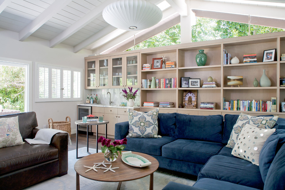Diseño de sala de estar con biblioteca marinera con paredes blancas y suelo de madera oscura
