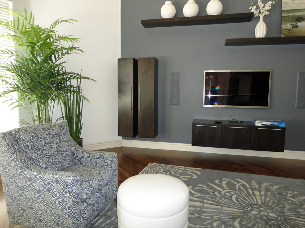 Idée de décoration pour une grande salle de séjour design ouverte avec un mur gris et un téléviseur fixé au mur.