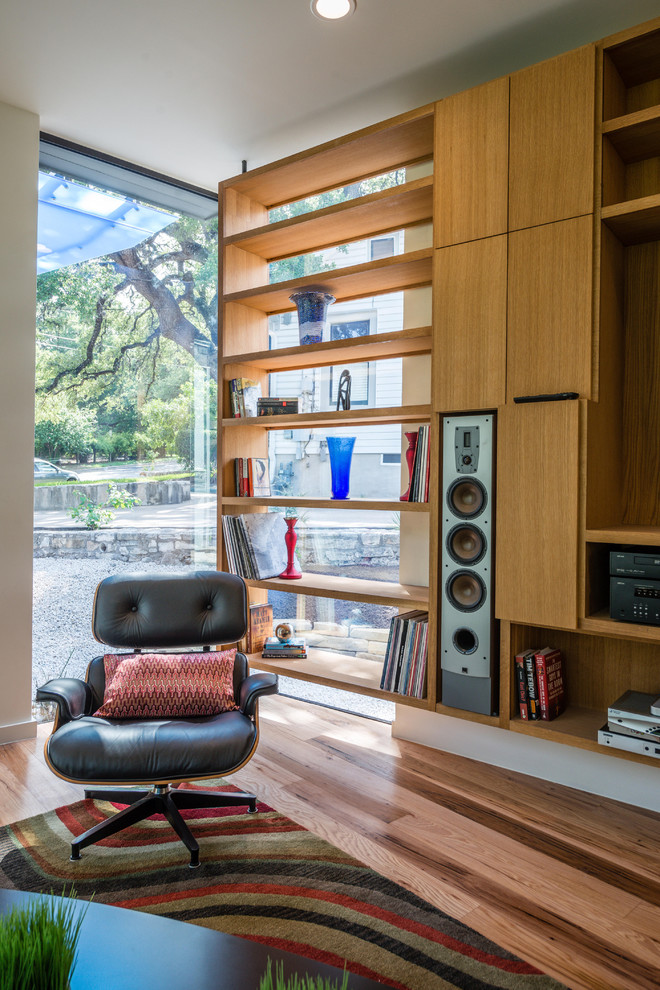 Example of a minimalist medium tone wood floor family room design in Austin