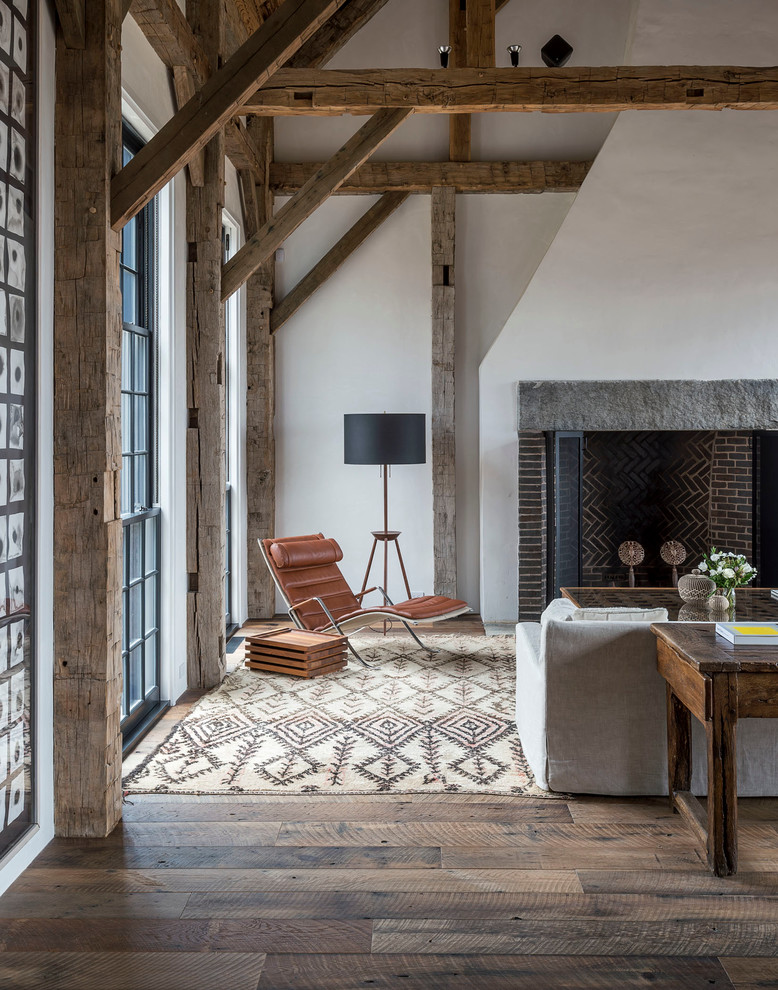 Idée de décoration pour une grande salle de séjour tradition ouverte avec un mur blanc, un sol en bois brun, une cheminée standard et un manteau de cheminée en brique.