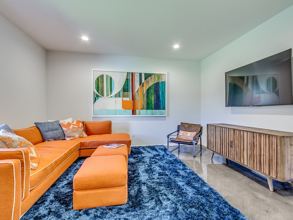 Großer, Abgetrennter Moderner Hobbyraum mit grauer Wandfarbe, Betonboden und TV-Wand in Oklahoma City