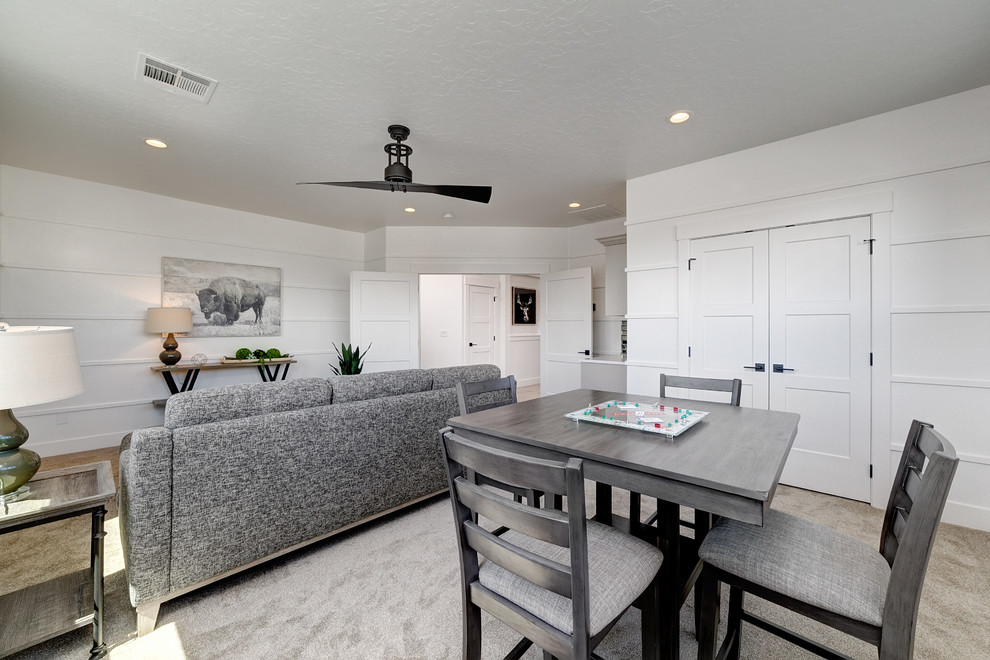 This is an example of a medium sized rural enclosed games room in Boise with a home bar, white walls, carpet and beige floors.