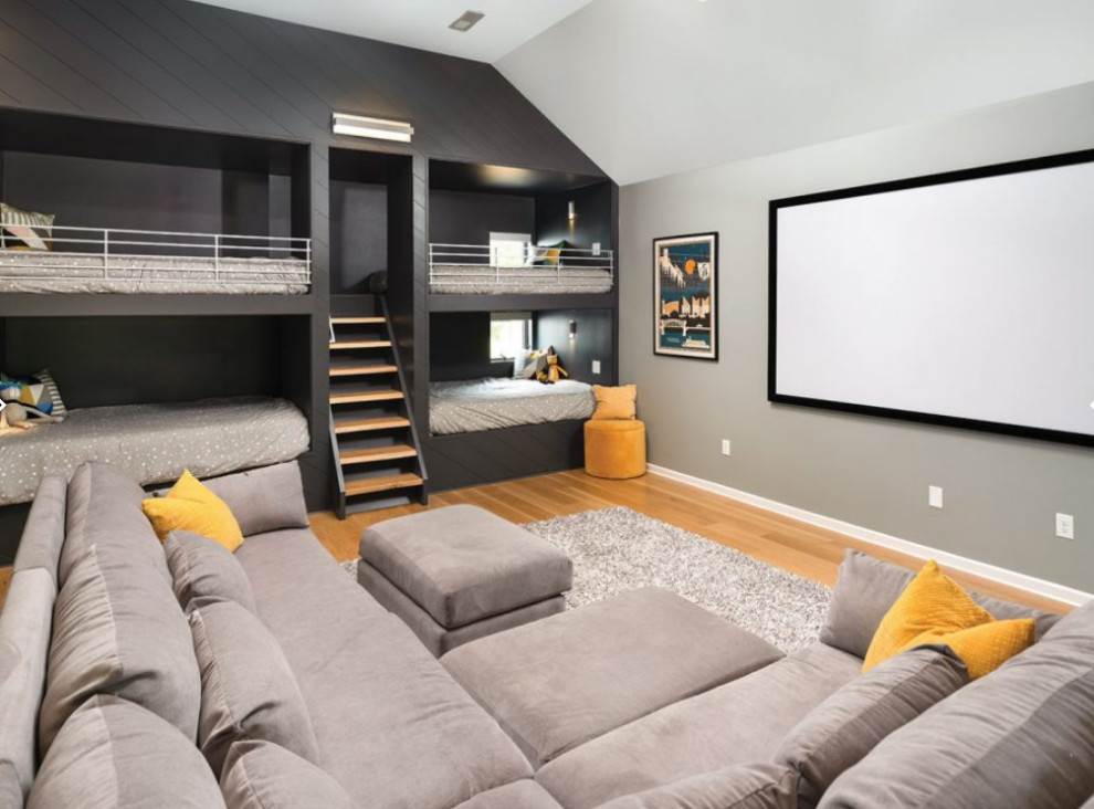 Immagine di un grande home theatre minimalista chiuso con pareti grigie, parquet chiaro, TV a parete e pavimento beige