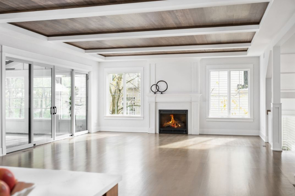 Inspiration for a large farmhouse open concept light wood floor, brown floor and exposed beam family room remodel in Chicago with white walls, a standard fireplace, a wood fireplace surround and a wall-mounted tv