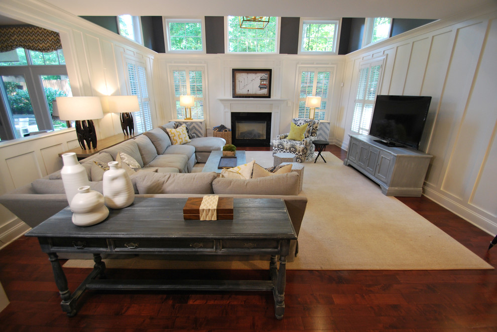 Exemple d'une grande salle de séjour nature ouverte avec un mur blanc, un sol en bois brun, une cheminée standard, un manteau de cheminée en bois, un téléviseur fixé au mur et un sol marron.