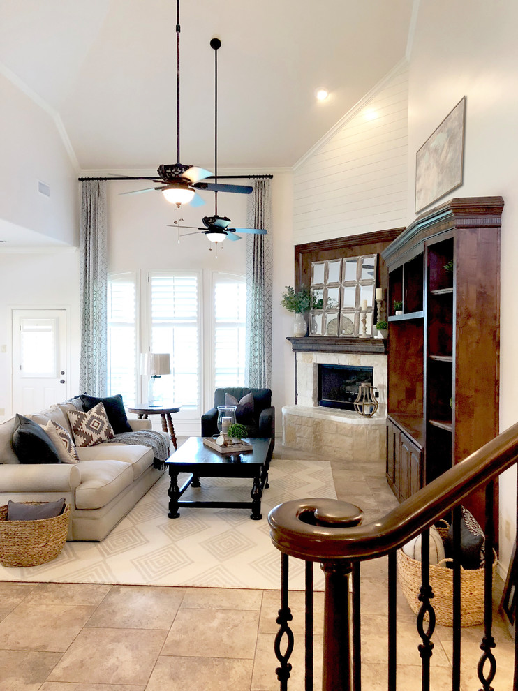 Imagen de sala de estar abierta de estilo de casa de campo grande con paredes beige, suelo de travertino, chimenea de esquina, pared multimedia y suelo beige
