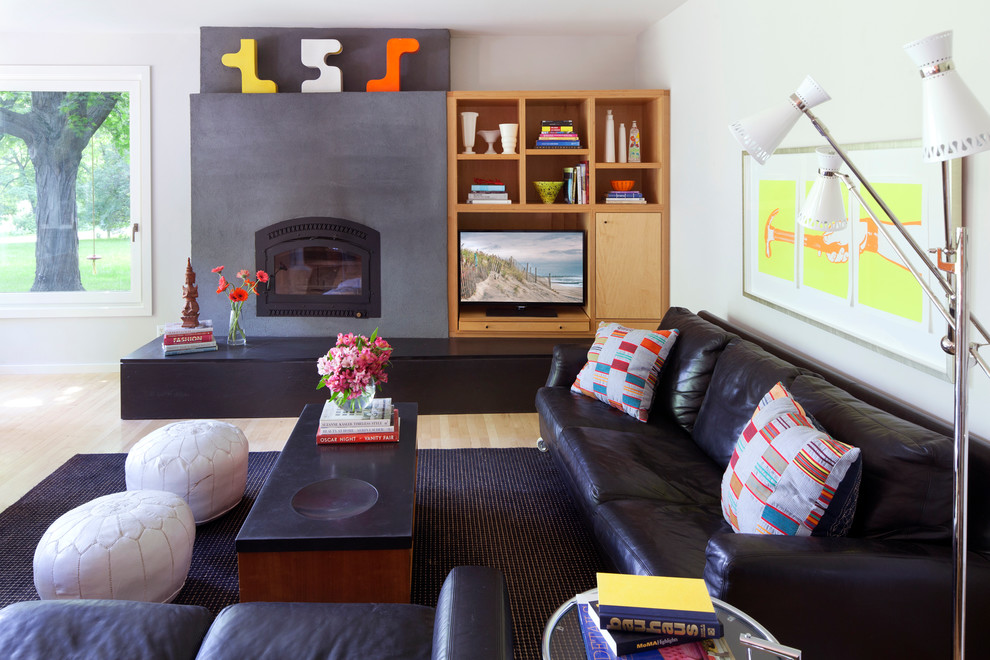 Cette photo montre une salle de séjour moderne ouverte avec un mur blanc, parquet clair, un manteau de cheminée en pierre et un téléviseur encastré.