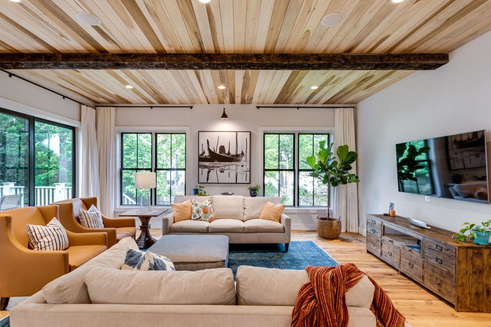 Idee per un soggiorno country con pareti bianche, parquet chiaro, TV a parete e pavimento beige