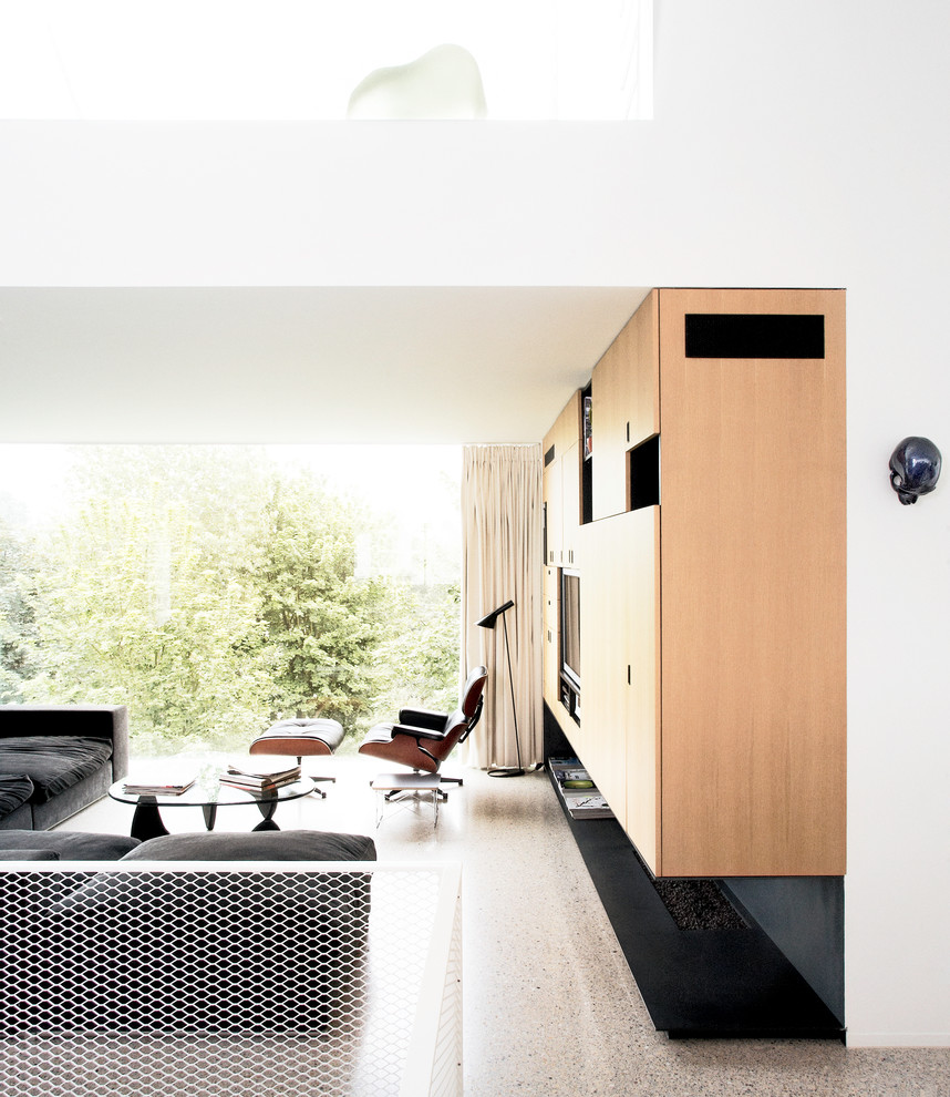 Cette photo montre une salle de séjour moderne avec un mur blanc, un téléviseur encastré et un sol beige.