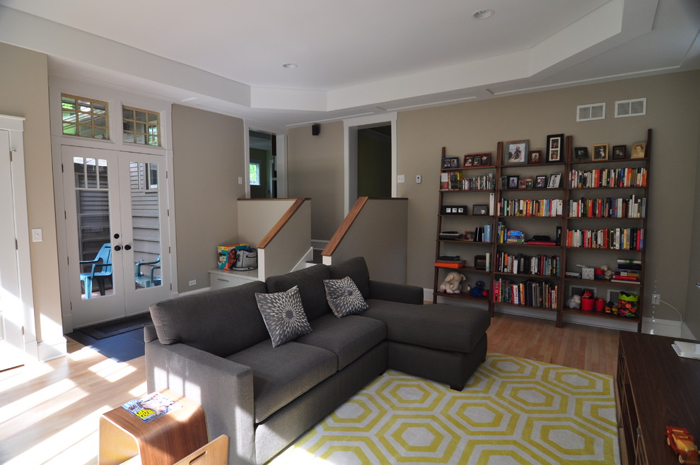 Imagen de sala de estar cerrada contemporánea grande sin chimenea con paredes beige y suelo de madera clara