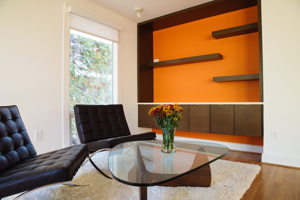 Inspiration för små moderna allrum med öppen planlösning, med ett bibliotek, orange väggar och ljust trägolv