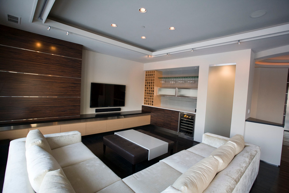 Idéer för ett stort modernt allrum med öppen planlösning, med en hemmabar, vita väggar, mörkt trägolv och en väggmonterad TV