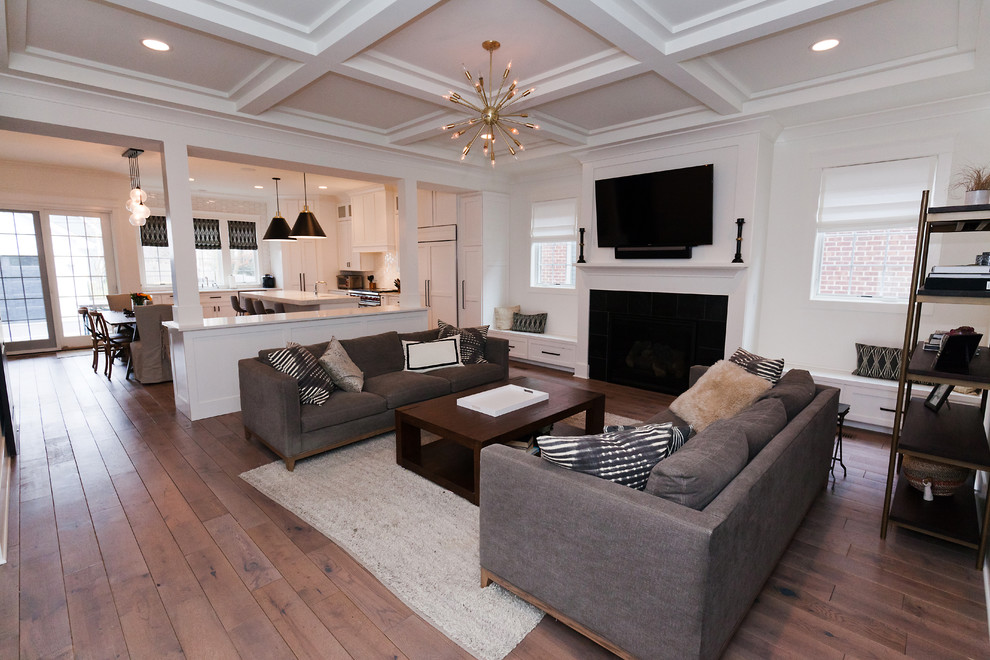 Large classic open plan games room in Chicago with white walls, medium hardwood flooring, a standard fireplace, a wooden fireplace surround, a wall mounted tv and brown floors.