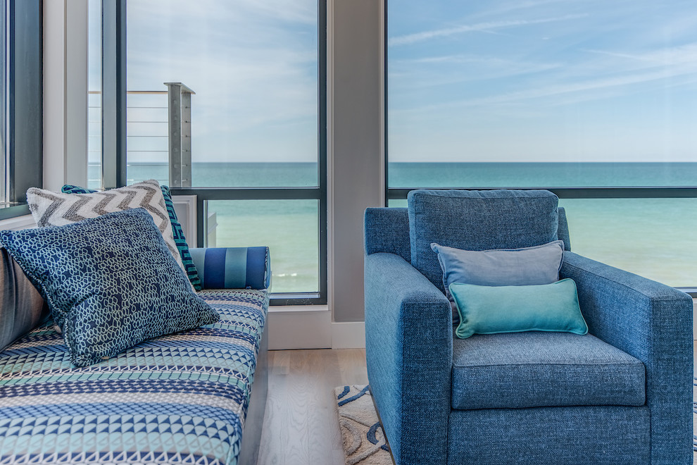 Foto di un grande soggiorno costiero aperto con angolo bar, pareti bianche, parquet chiaro e pavimento beige