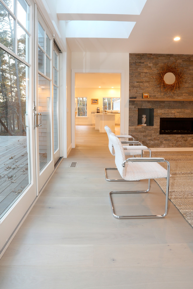 Cette photo montre une salle de séjour moderne de taille moyenne et ouverte avec un mur blanc, parquet clair, un manteau de cheminée en brique, aucun téléviseur et un sol gris.