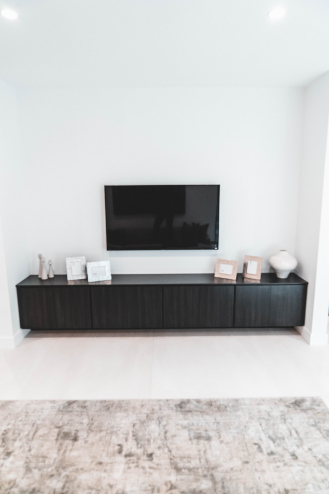 На фото: большая открытая гостиная комната в стиле модернизм с полом из керамической плитки, телевизором на стене и белым полом