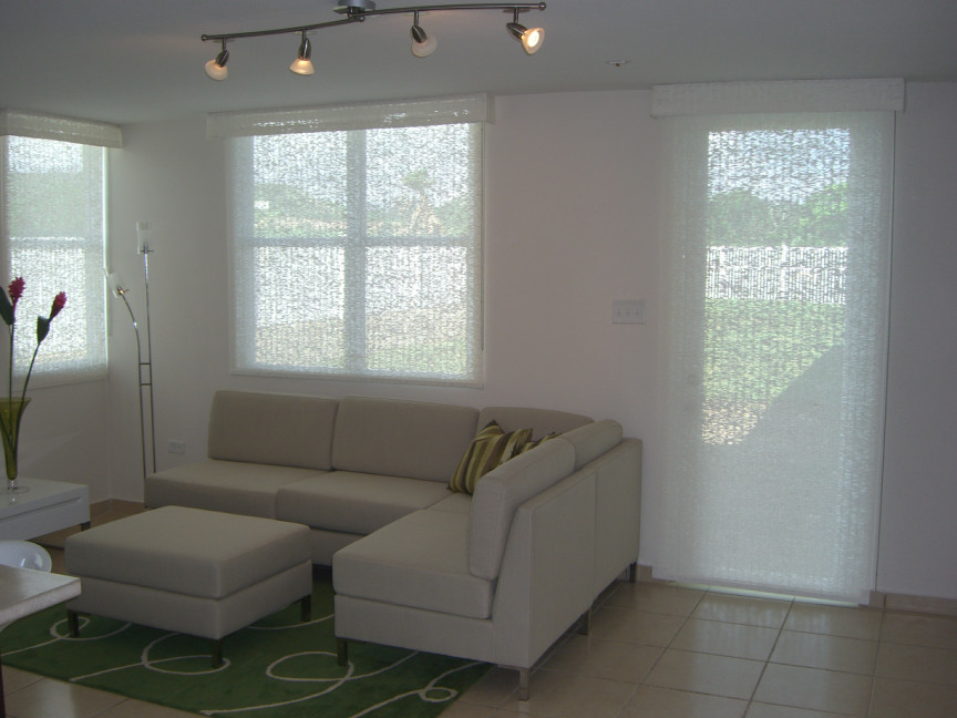 Foto på ett litet funkis avskilt allrum, med ett musikrum, vita väggar, marmorgolv, TV i ett hörn och beiget golv