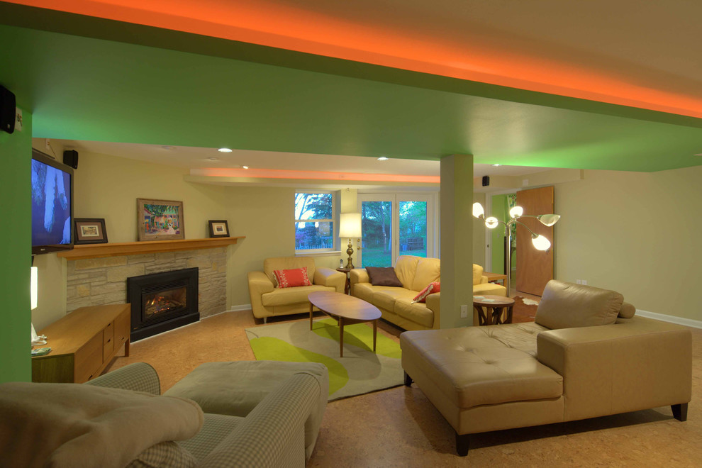 Foto di un grande soggiorno minimalista aperto con pareti beige, pavimento in sughero, camino ad angolo, cornice del camino in pietra e TV a parete