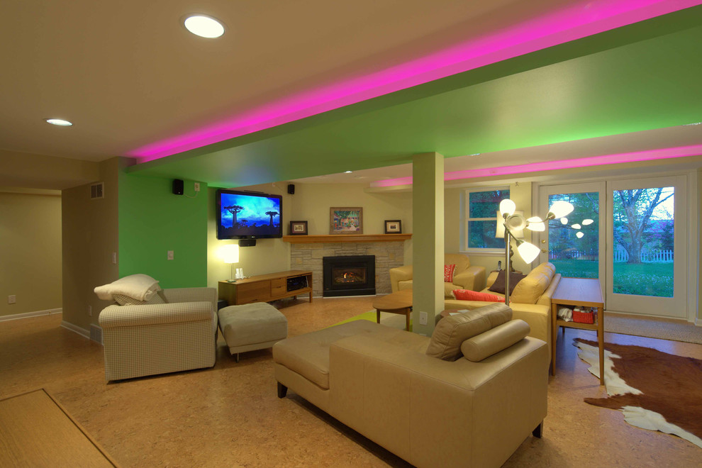Foto di un grande soggiorno moderno aperto con pareti beige, pavimento in sughero, camino ad angolo, cornice del camino in pietra e TV a parete
