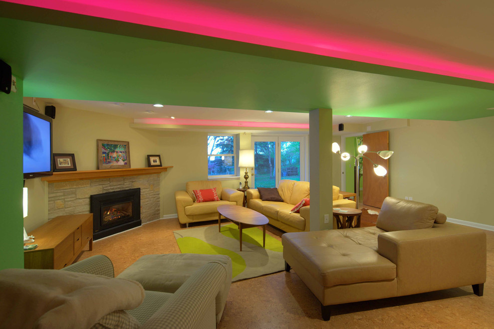 Immagine di un grande soggiorno minimalista aperto con pareti beige, pavimento in sughero, camino ad angolo, cornice del camino in pietra e TV a parete